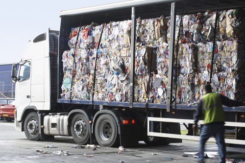 Workers loading items into a van for rubbish removal